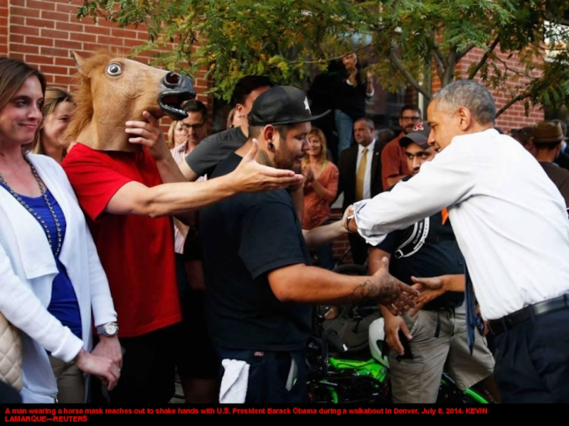 A man wearing a horse mask reaches out to shake hands