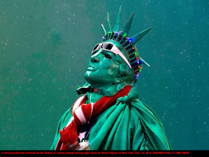 A street performer dressed as the Statue of Liberty stands among