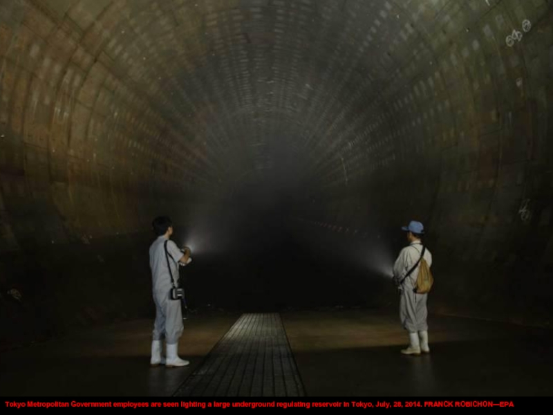 Tokyo Metropolitan Government employees are seen lighting a large underground regulating