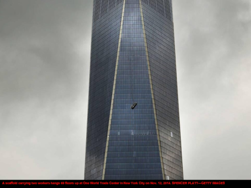 A scaffold carrying two workers hangs 69 floors up at One