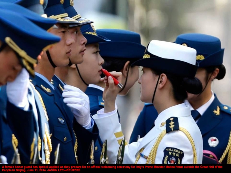 A female honor guard has lipstick applied as they prepare for